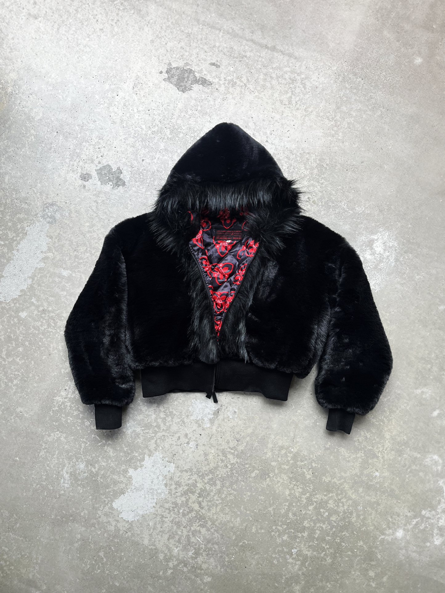 Veste crop en deux fourrures synthétiques noires , ajustée à la taille et légèrement oversize. Elle est doublée en satin imprimé à logo Les Garçons Pleurent.