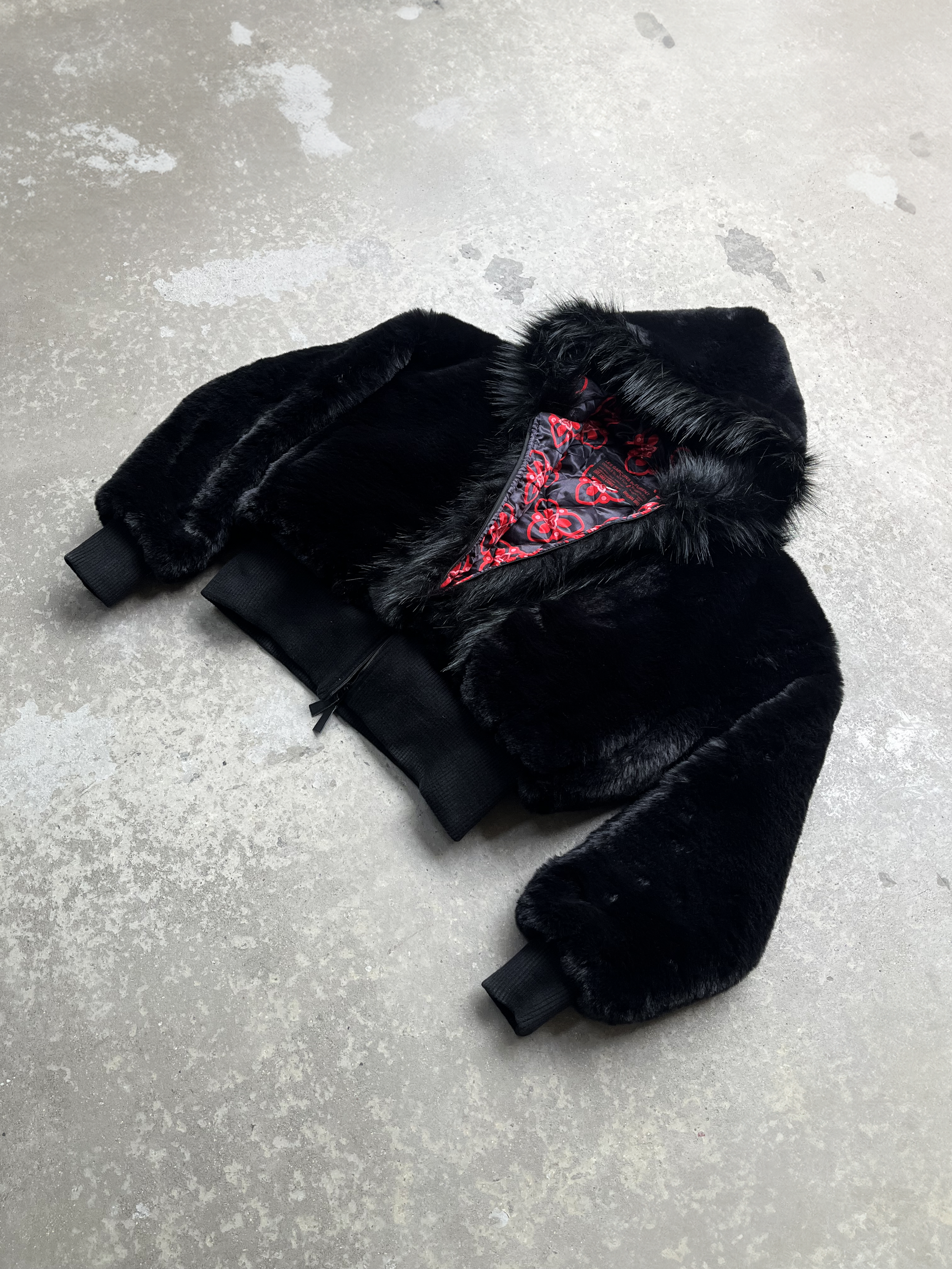 Veste crop en deux fourrures synthétiques noires , ajustée à la taille et légèrement oversize. Elle est doublée en satin imprimé à logo Les Garçons Pleurent.